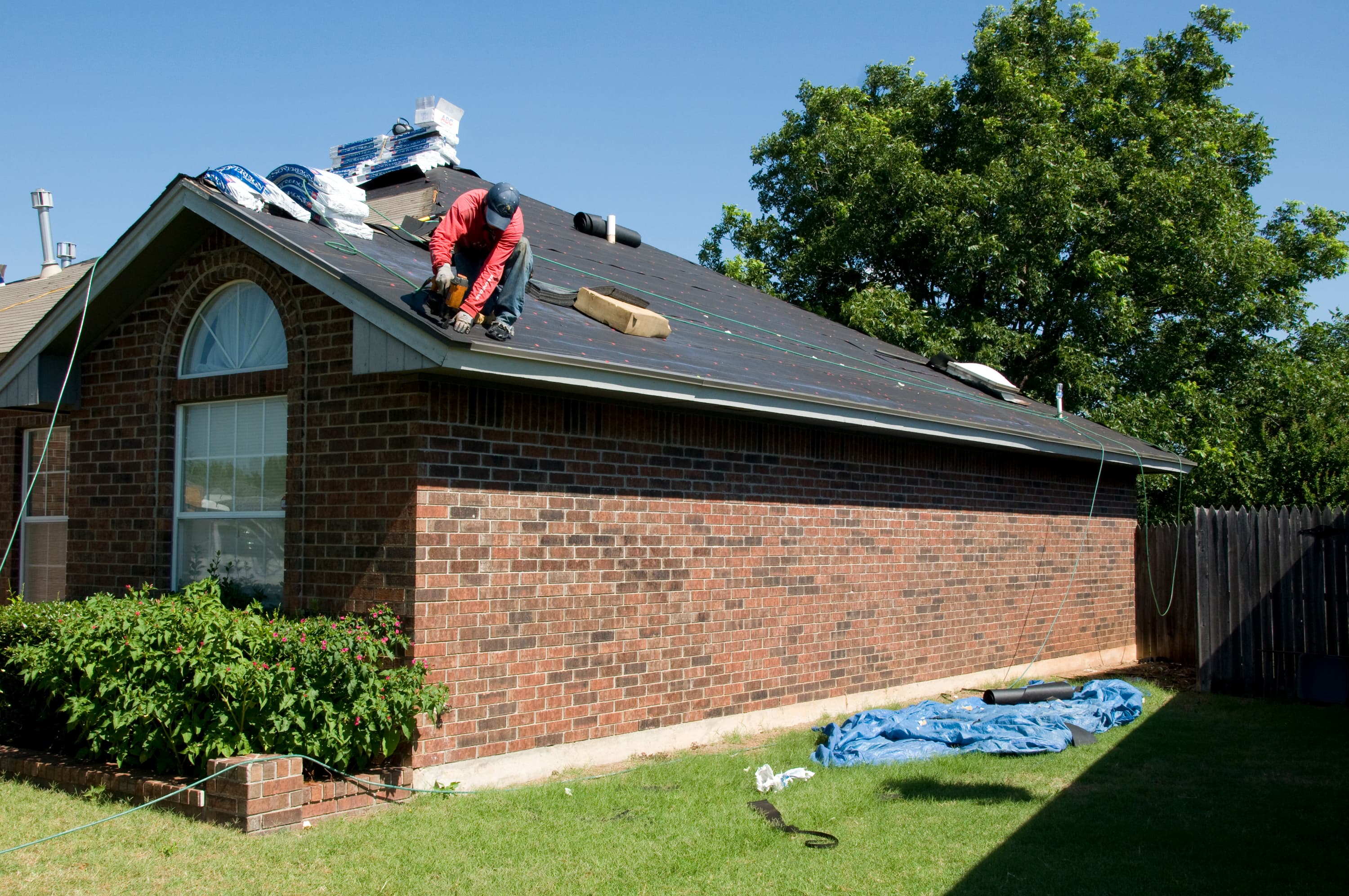 Roofer installing new shingles on a residential home